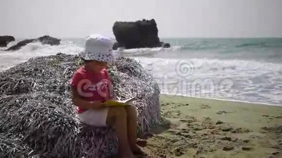 坐在海滩上的小女孩视频的预览图