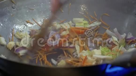 厨师在热锅里混合炒菜视频的预览图