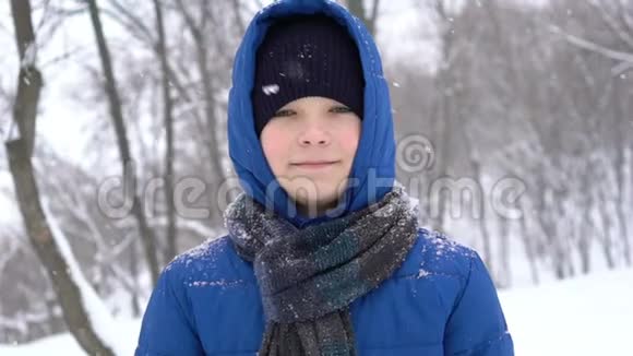 冬天森林里一个年轻人的肖像大雪纷飞视频的预览图