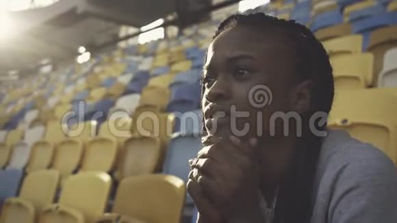 紧张的美国黑人女子独自坐在体育场里视频的预览图