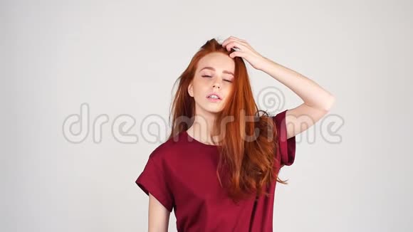 白色背景下红头模型的流行肖像完美女孩在工作室摆姿势慢动作视频的预览图