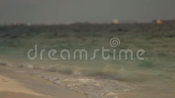 小海浪在马尔代夫热带海滩的沙滩上冲浪特写镜头视频的预览图