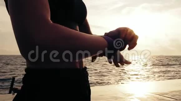 年轻的健康女性准备好了她的拳头准备拳击手套在他们周围包裹绷带站在阳光下视频的预览图
