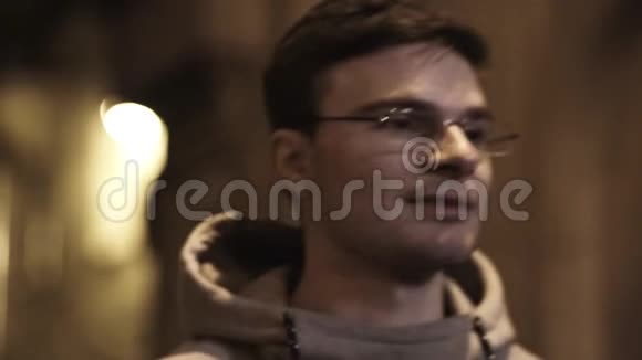 戴眼镜的年轻人的肖像在小巷里转了转视频的预览图