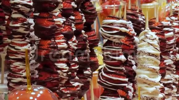 货架上塑料杯里的不同水果和水果市场巧克力釉里的草莓的混合视频的预览图