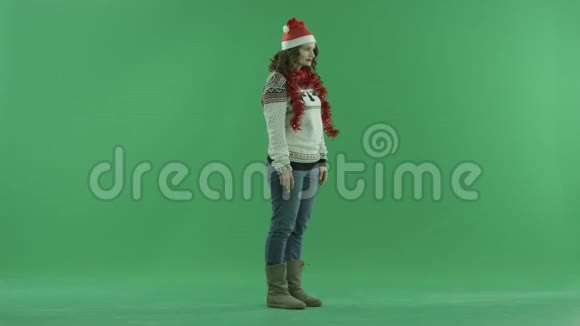 戴着圣诞帽的迷人女人跳舞吹着口哨背景上的彩色钥匙视频的预览图