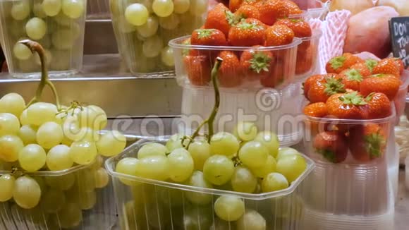市场上新鲜的葡萄草莓和热带水果架视频的预览图