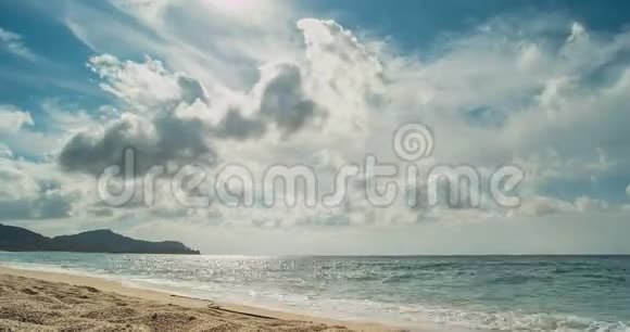 海滩和后面的山脉从云彩中发出太阳的光芒时光流逝视频的预览图