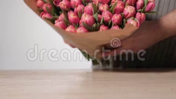 园丁花店工作特写淡粉色郁金香在男性手中视频的预览图