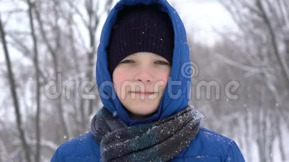 冬天森林里一个年轻人的肖像大雪纷飞视频的预览图