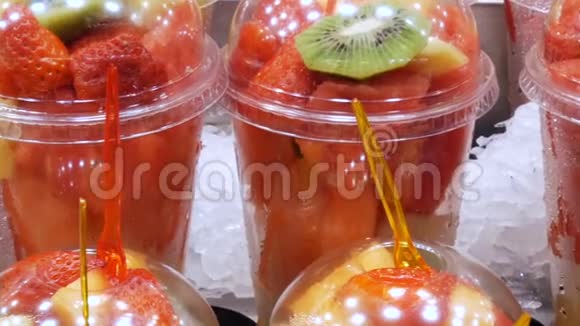 新鲜的刚装在塑料杯里混合着西瓜猕猴桃梨苹果草莓近距离观看视频的预览图
