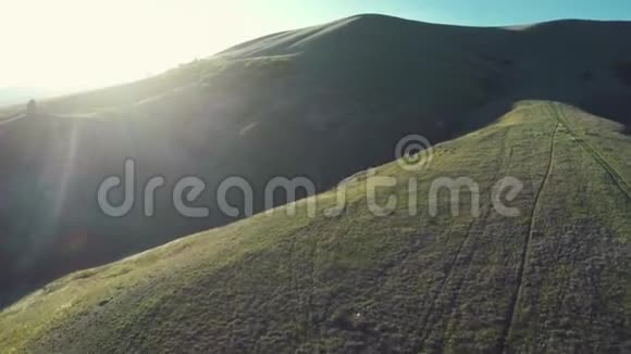 带山的山谷上空日落时的空中飞行视频的预览图