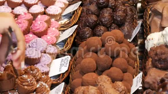 市场柜台上有美味的巧克力糖果女人手里拿着巧克力松饼视频的预览图