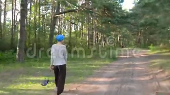 幸福的女人穿着蓝色的头巾在森林里散步假期概念视频的预览图