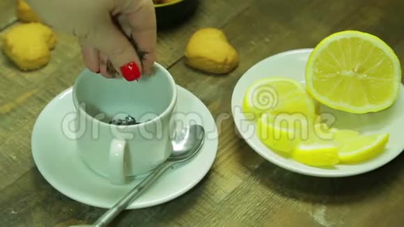 女人的手在白色的杯子里倒红茶平均计划视频的预览图