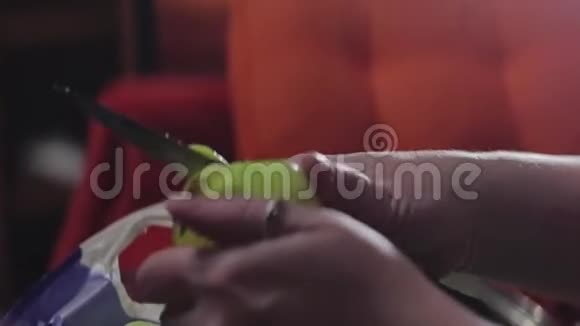 用刀子清洗苹果的女孩的手左边的特写镜头视频的预览图