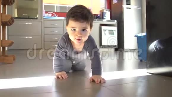 可爱的小男孩在地板上滑稽地爬行视频的预览图