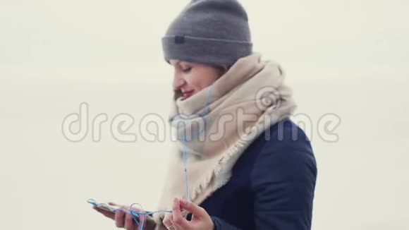 一个年轻漂亮的女人在户外散步时听音乐跳舞视频的预览图