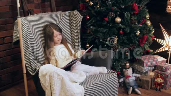 女孩在圣诞树附近看书视频的预览图