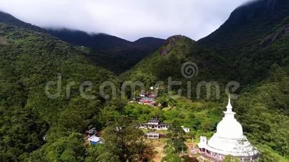 在斯里兰卡亚当山顶用寺庙从定居点的顶部进行空中特写视频的预览图