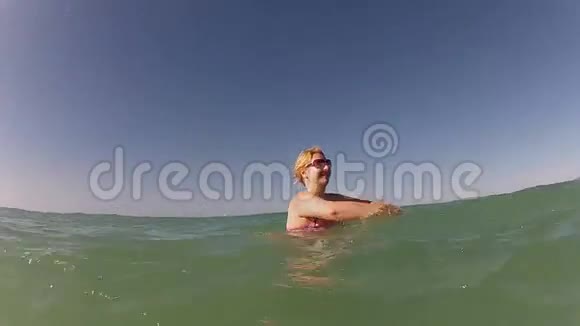年轻的金发女人在海里玩得开心视频的预览图