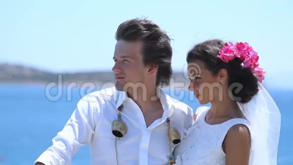 可爱的新婚夫妇在海滩上接吻视频的预览图