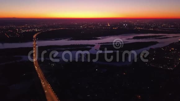 俄罗斯新西伯利亚航空视频日落时分的夜城夕阳映在河里在桥上开车视频的预览图
