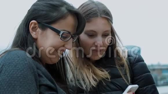 两个女孩在手机上看照片视频的预览图