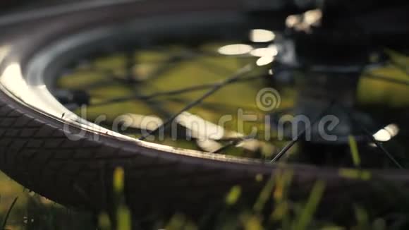 自行车轮躺在绿草上靠近躺在草地上的自行车视频的预览图