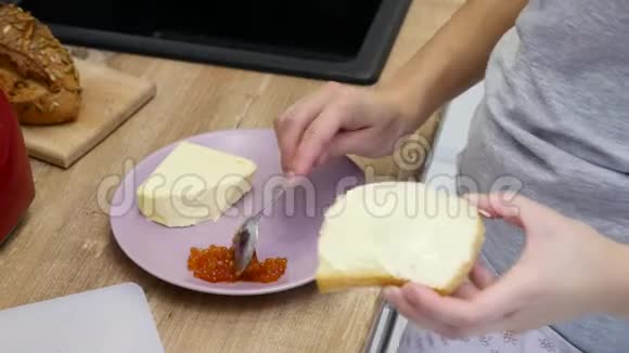 用红鱼子酱做三明治的女性手视频的预览图