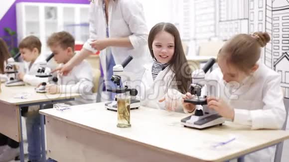 小学生物化学课孩子们透过显微镜看视频的预览图