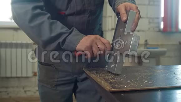男性工作手用刮刀研磨金属体视频的预览图