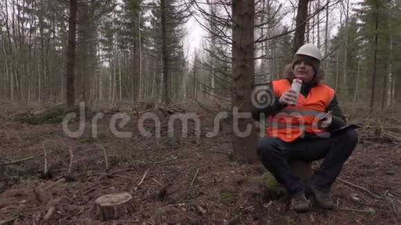 伐木工人在森林里坐着喝咖啡视频的预览图