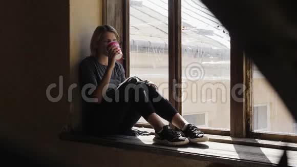 带着咖啡的年轻女孩坐在忧郁症中视频的预览图