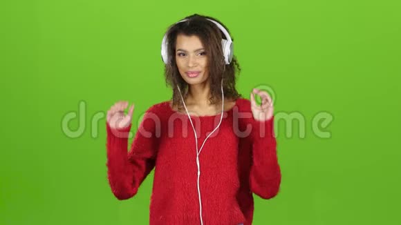 带着耳机在绿色屏幕背景下跳舞的美国黑人女孩视频的预览图