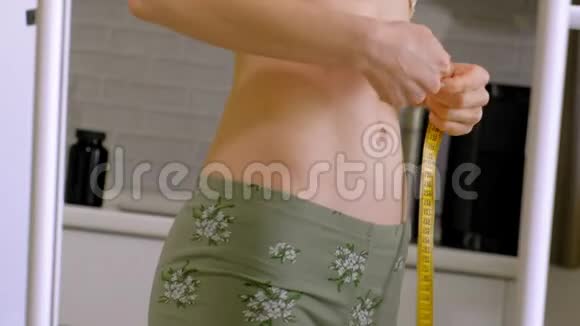 苗条的女人测量他的腰部健康的饮食健康的生活方式观念健身饮食视频的预览图