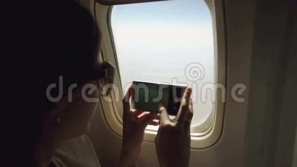 在飞机上拍照的年轻女子在飞机上拍照视频的预览图
