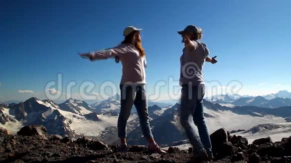 两个女孩抱在山顶上双臂举过头顶视频的预览图