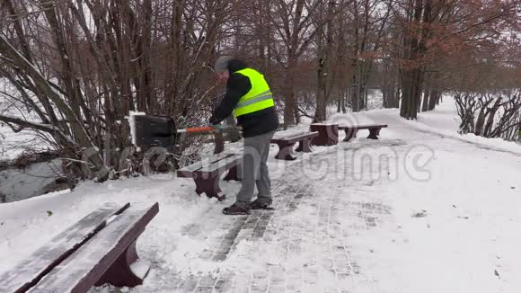 有雪铲的看门人在长凳附近工作视频的预览图