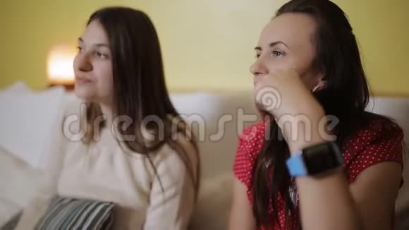 两个女朋友在家里一起在沙发上看电视视频的预览图