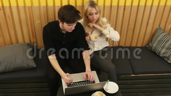 Hipster夫妇坐着用笔记本电脑喝咖啡视频的预览图