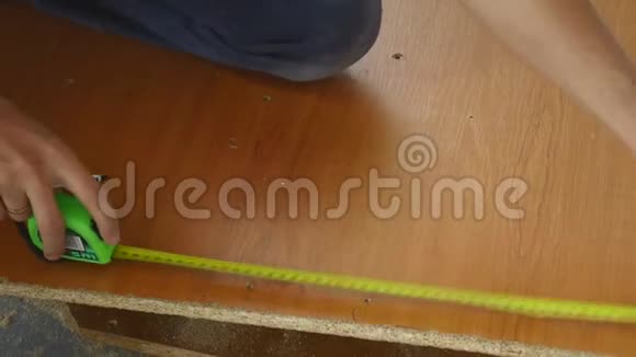 这个人用卷尺测量木板的长度并做铅笔记号视频的预览图