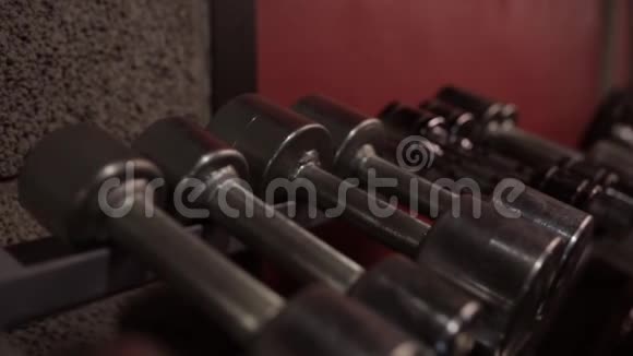 从健身房的储物架上拿哑铃的人视频的预览图