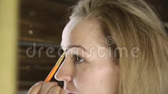 美丽的女人在镜子前画眉毛视频的预览图