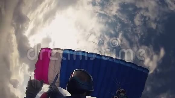 跳伞者戴着头盔跳伞在多云的天空中身高准备着陆速度视频的预览图