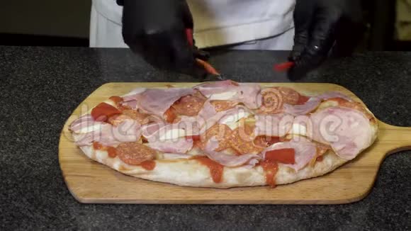 厨师戴着黑色烹饪手套在木板上做披萨美味的食物概念框架双手合拢视频的预览图