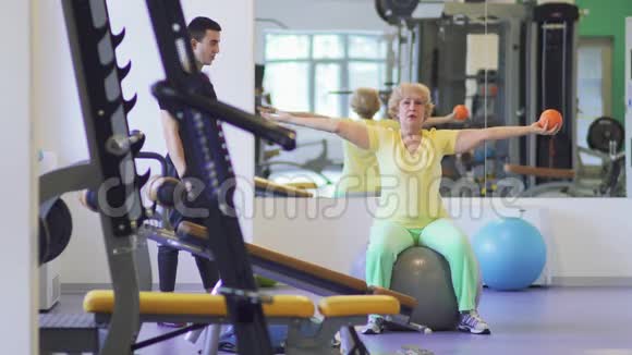 老年妇女在健身房用球做健身运动视频的预览图