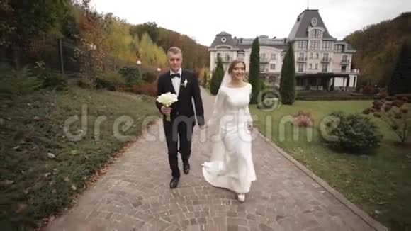 在公园散步的漂亮夫妇新郎和新娘视频的预览图