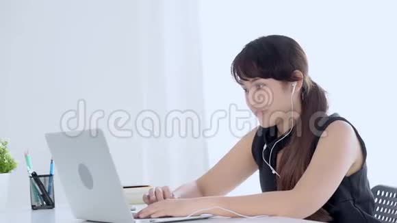 美丽的年轻亚洲女人微笑着用聊天社交网络和笔记本电脑视频通话打招呼视频的预览图