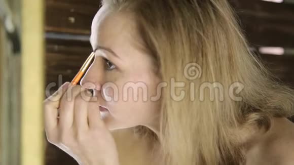 美丽的女人在镜子前画眉毛视频的预览图